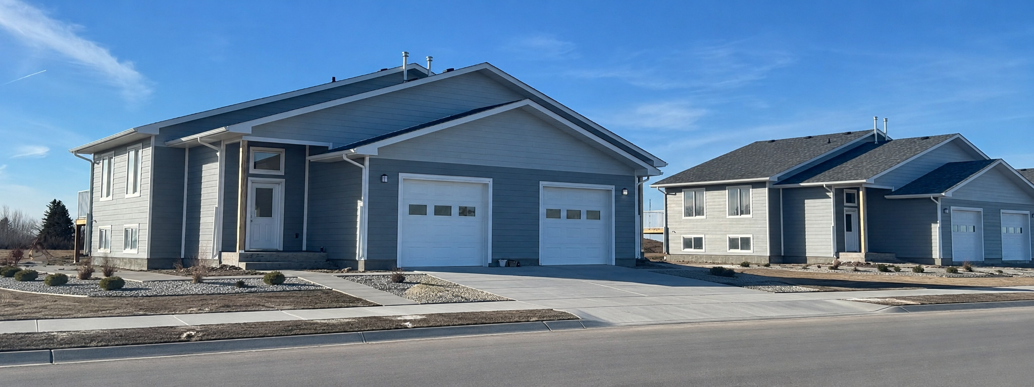 Multi-family rental homes with paired garages, coordinated exterior finishes and landscaped site development. Multi-family rental homes with paired garages, coordinated exterior finishes and landscaped site development.