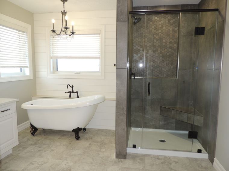 Classic ensuite with a clawfoot tub, glass shower, shiplap wall detail and grey tile finishes.
