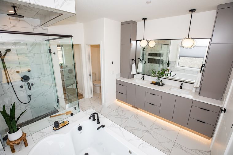 Contemporary primary ensuite with a long floating vanity, under-cabinet lighting, glass shower and soaker tub.