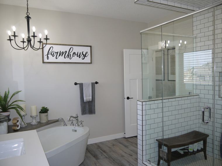Modern farmhouse ensuite with a clawfoot tub, glass shower, white subway tile and shiplap detailing.