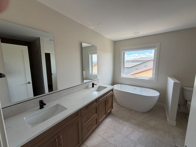 Primary ensuite with double vanity and freestanding tub