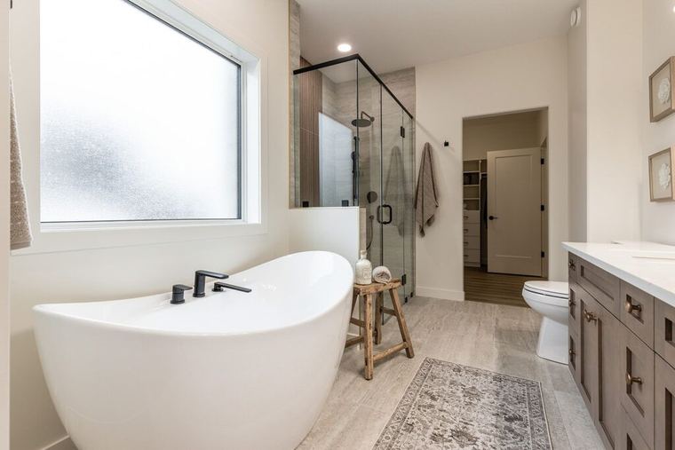 The Devon — primary ensuite with freestanding tub, glass shower and double vanity