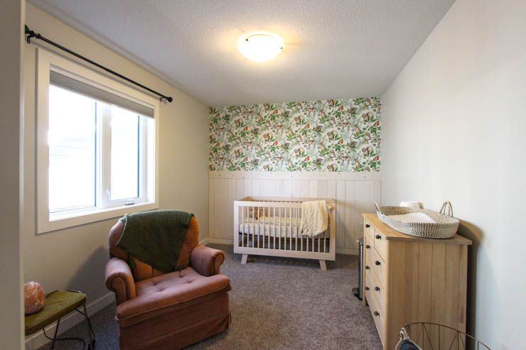 Custom Clive — nursery with botanical feature wall and warm wood furniture