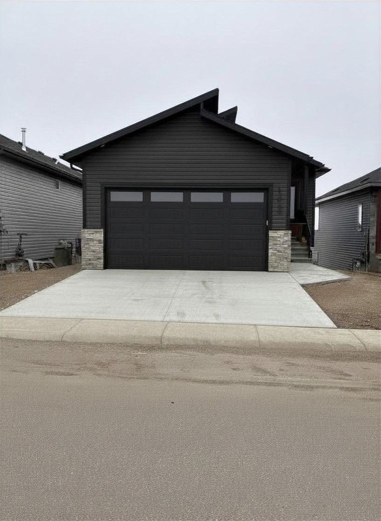 Modern black starter home with a single-car garage and clean contemporary exterior.