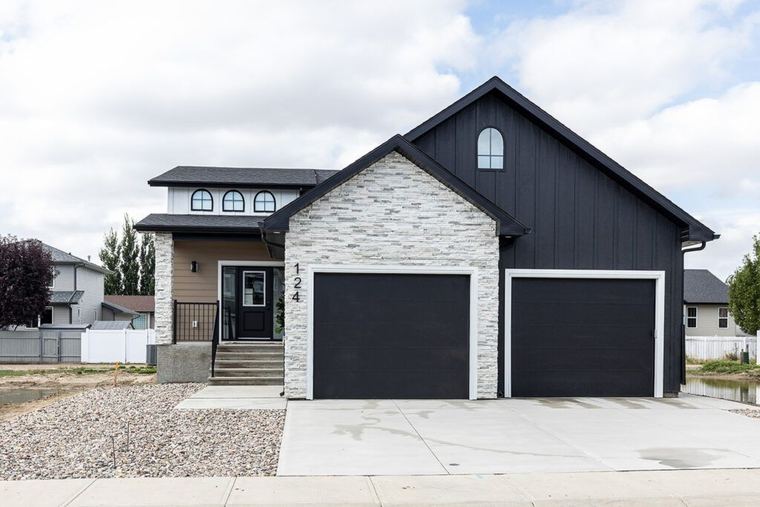 The Devon — contemporary Parade of Homes exterior with stone accents and a two-car garage