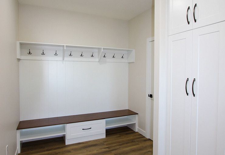Custom Farm Home — built-in mudroom bench, hooks, storage and full-height cabinetry