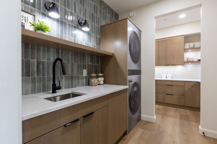 The Fairview — laundry room with sink, stacked appliances and coordinated cabinetry
