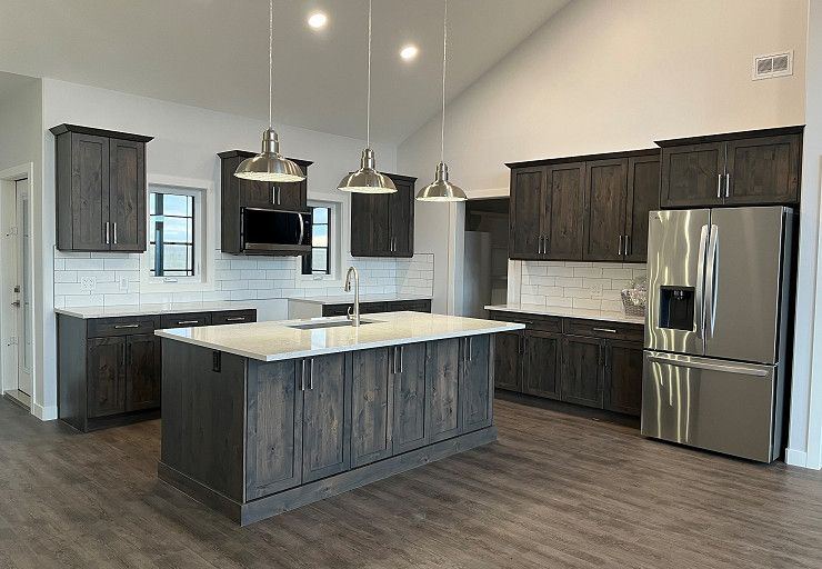 Custom Everest I Prairie Edition — dark wood kitchen with oversized island and vaulted ceiling