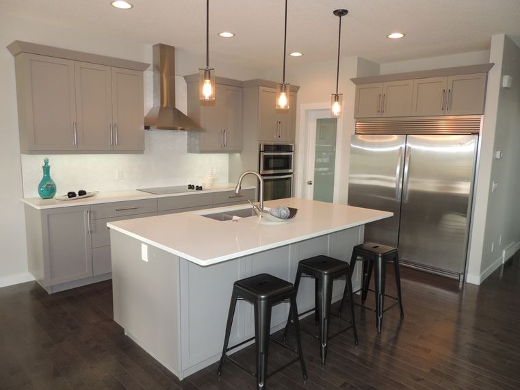 Contemporary grey kitchen with a white quartz island, stainless-steel appliances, pendant lighting and black counter stools.
