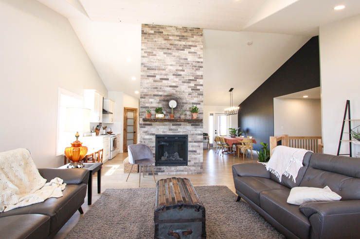 Custom Clive — open great room organized around a floor-to-ceiling stone fireplace