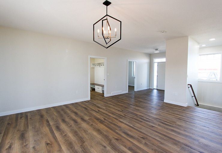 Custom Farm Home — open living area with contemporary lighting and connection to the mudroom