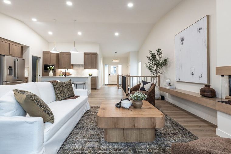 The Devon — vaulted living room with modern fireplace, built-in ledge and open kitchen connection