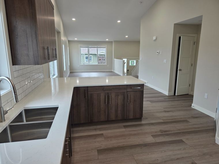Open-concept rental suite main floor with durable finishes, a kitchen island and flexible living space.