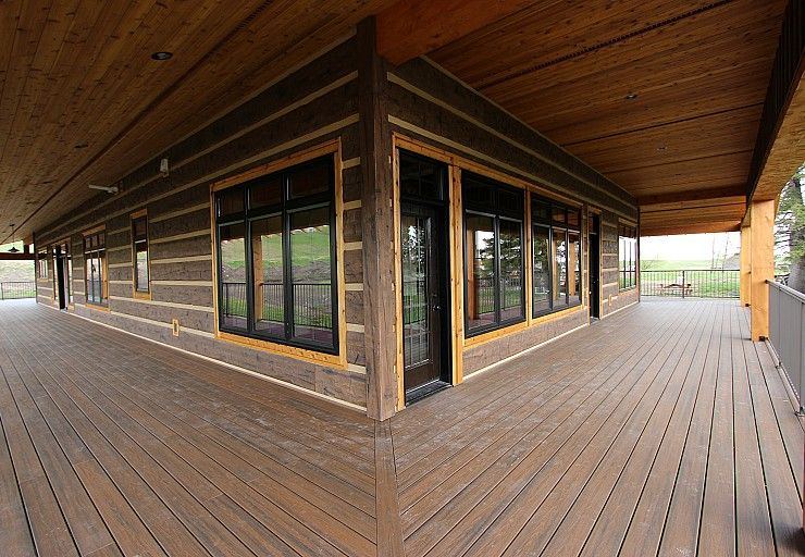 Custom Cabin — expansive covered wraparound deck overlooking the ranch property