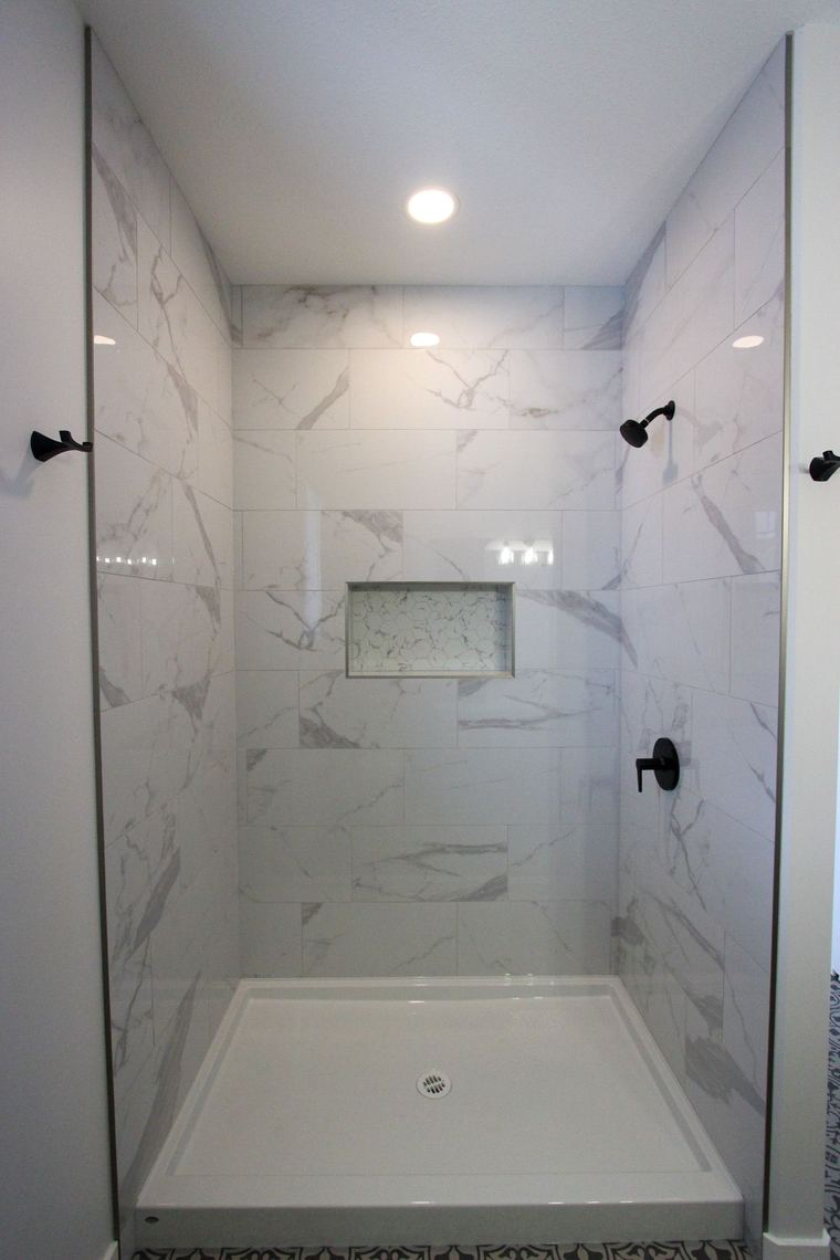 RTM showhome — full-height tiled shower with glass enclosure and recessed niche