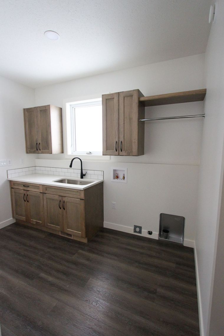 RTM showhome — dedicated laundry room with sink, cabinetry and hanging space