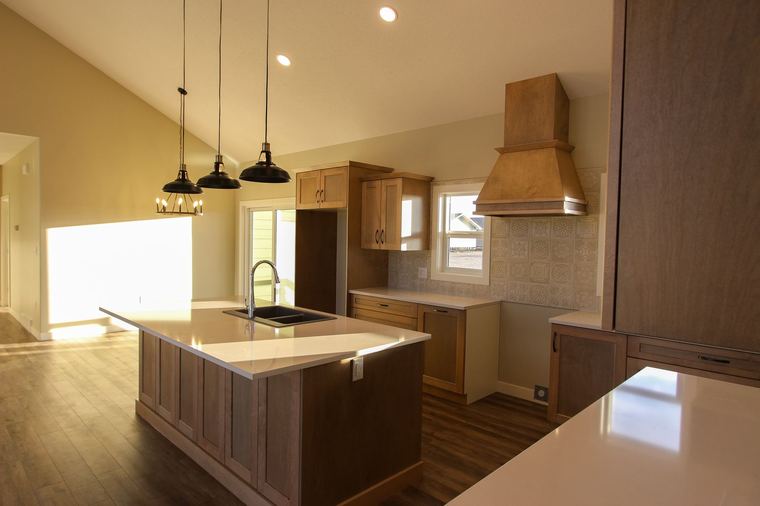 Acreage RTM — warm wood kitchen with large island and custom range hood