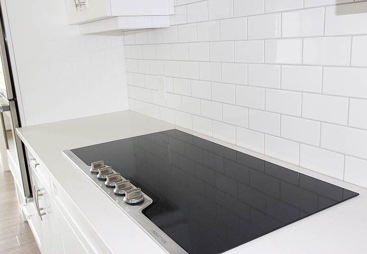 Custom Mankota I RTM — integrated cooktop and bright subway-tile backsplash