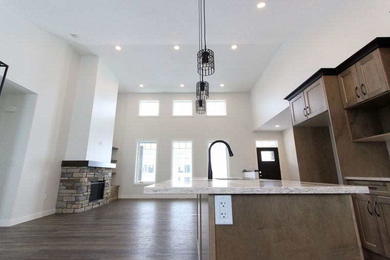 RTM home — bright open-concept kitchen and great room with stone fireplace