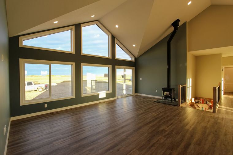 Acreage RTM — vaulted living room with window wall and wood stove
