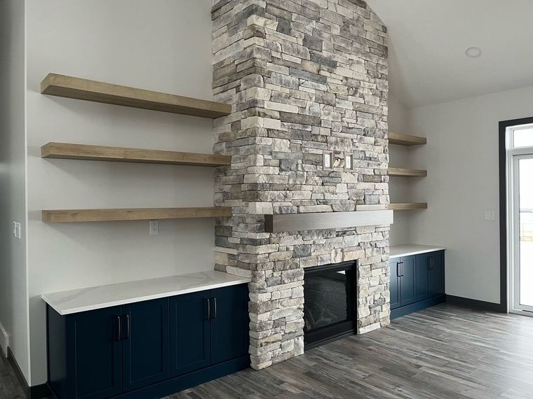 RTM home — floor-to-ceiling stone fireplace with floating shelves and built-in cabinetry